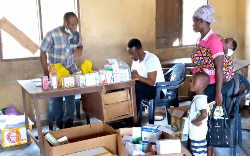 a128Y00000DCIBT_GH0644_- Beneficiary and his mother recieving their drugs after the health screening exercise