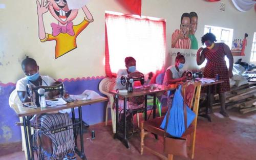Caregivers participate in a sewing class at the center. Out of the eight caregivers participating in this course, five of them found jobs sewing uniforms for schools in their neighborhoods.